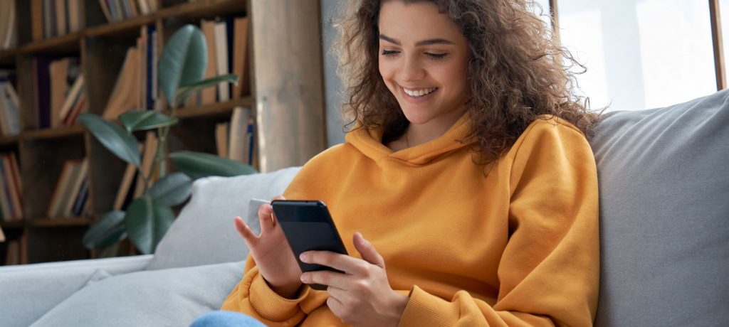 Woman sitting on couch looking at phone